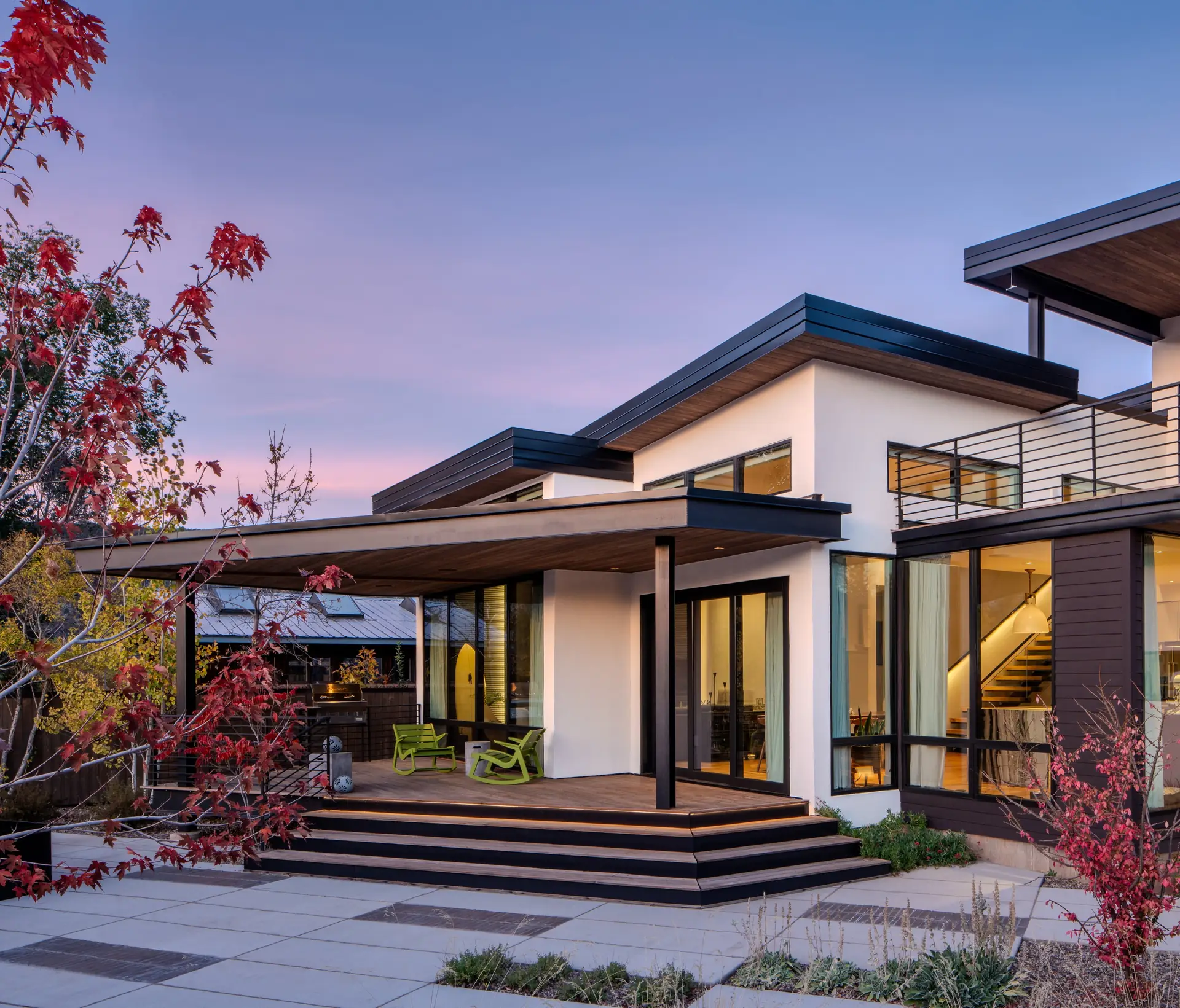 Modern house at dusk with a black steel balcony railing